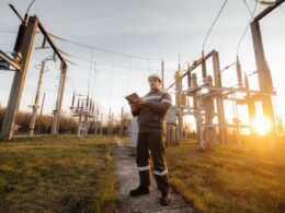 Pracownicy montują słupy energetyczne podczas budowy linii przesyłowej